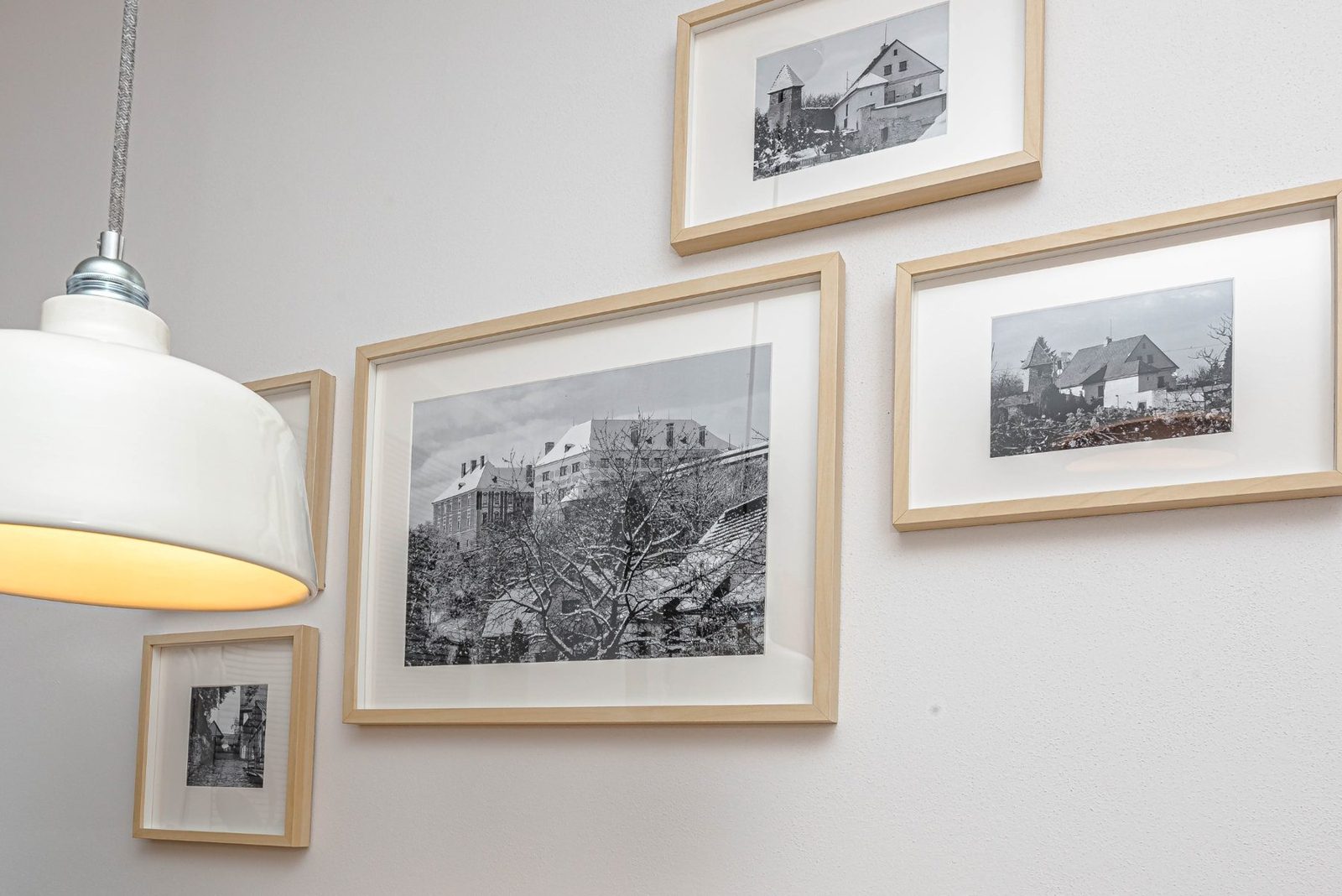 Galerie zarámovaných fotografií nad jídelním koutem